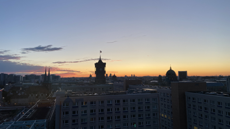 Blick über die Dächer Berlins bei Sonnenaufgang. Im Zentrum der Turm des Roten Rathauses
